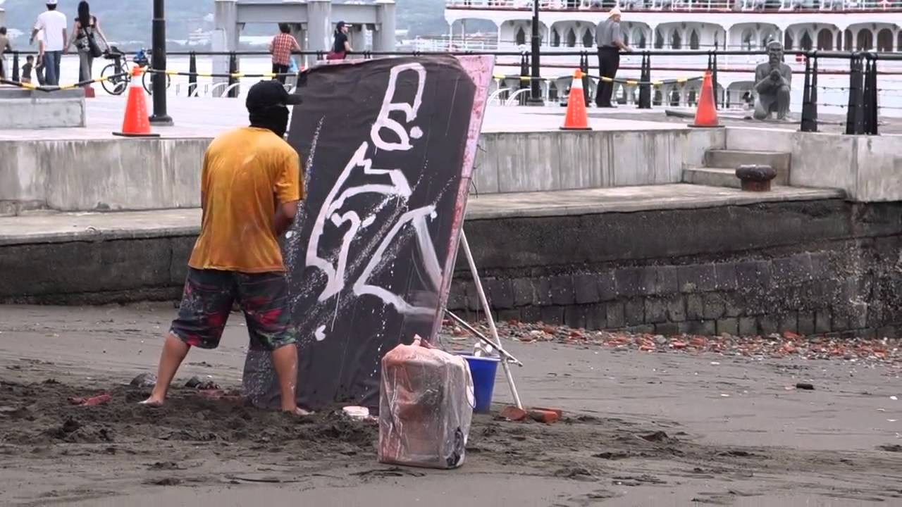 Artysta uliczny maluje portret… do góry nogami.