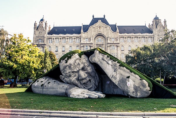 Gigantyczna rzeźba wychodzi z ziemi na placu w Budapeszcie.