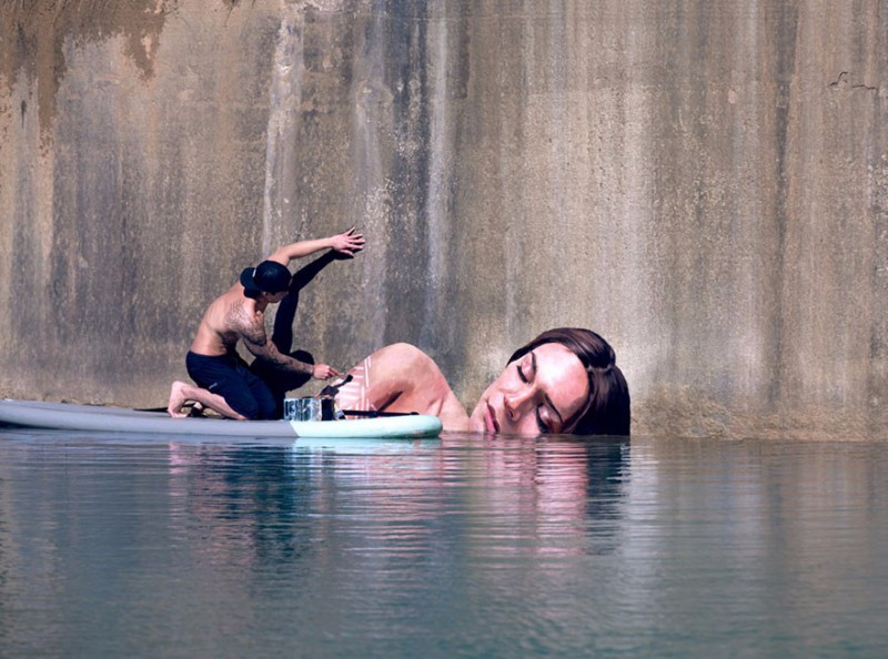 Artysta tworzy niesamowite wodne murale, balansując na desce surfingowej.
