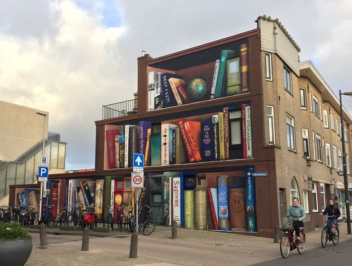 Holenderscy artyści malują olbrzymi regał na bloku z ulubionymi książkami mieszkańców!