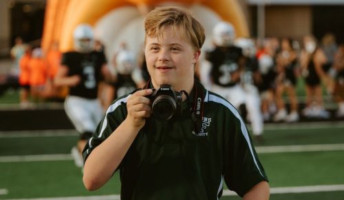 Poznaj nastoletniego fotografa sportowego z zespołem Downa, który podbił społeczność Hearts of Texas!