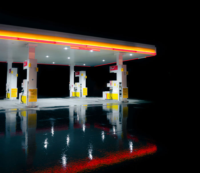 Empty gas station illuminated at night with reflections on wet ground