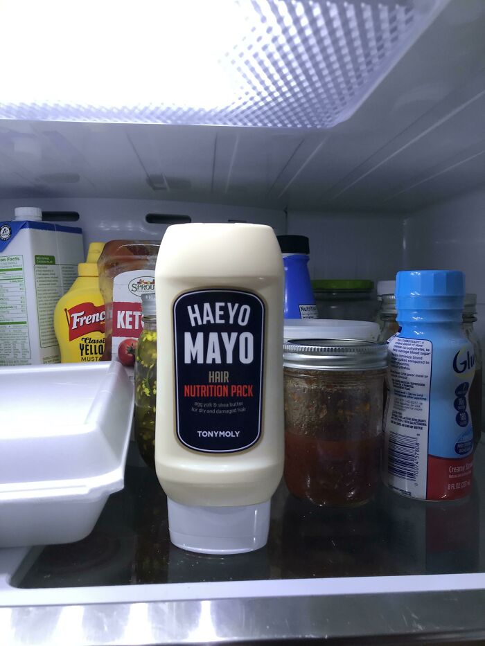 A bottle of Tonymoly Haeyo Mayo Hair Nutrition Pack in a refrigerator, appearing like a forbidden food item. Do not eat.