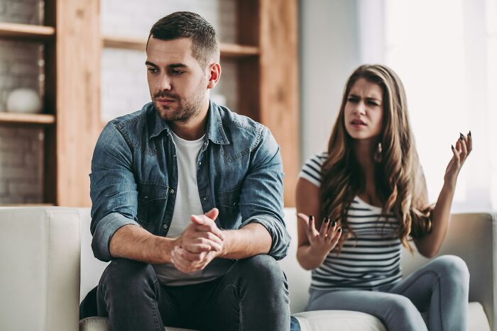 Couple having tense discussion with woman upset and man looking away