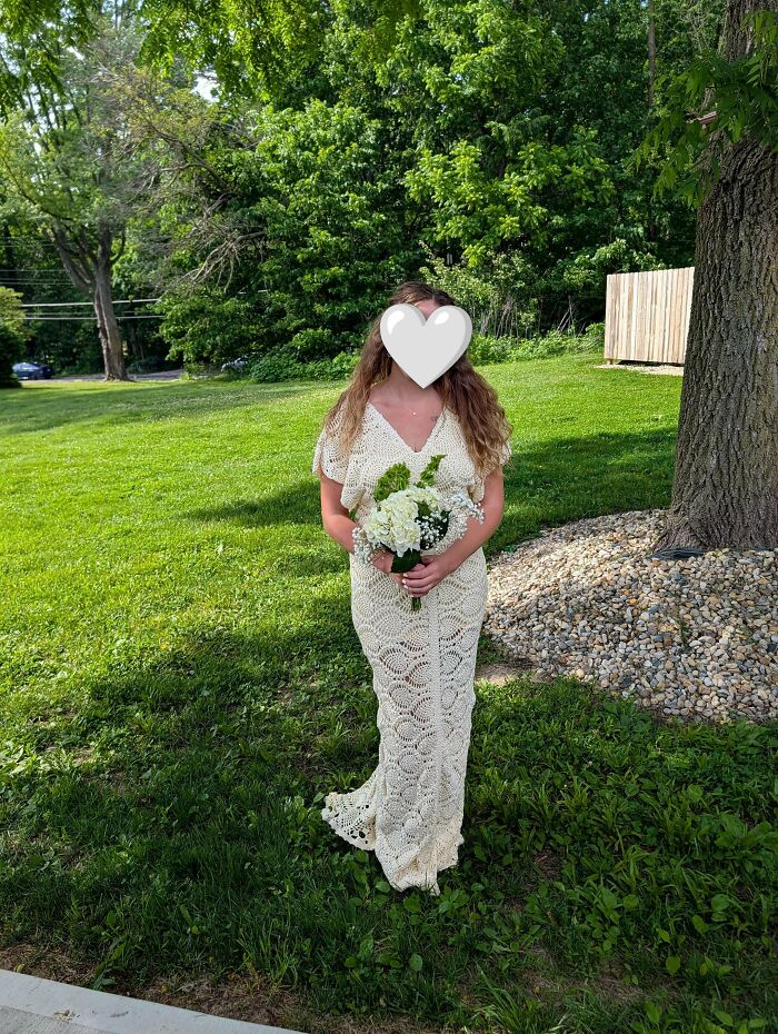 Woman wearing elegant crochet wedding dress outdoors