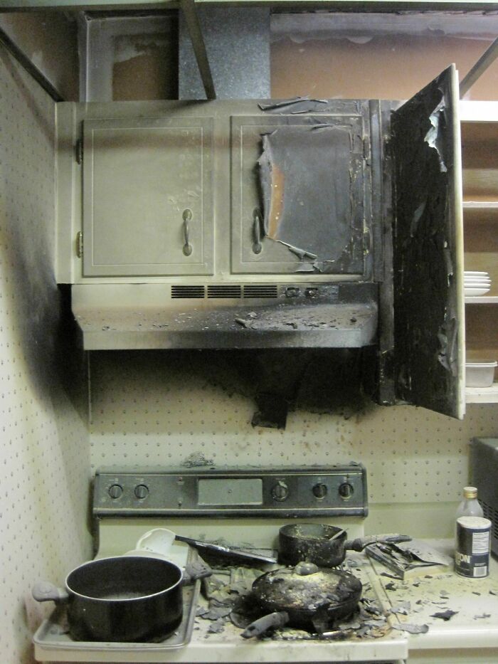 A devastating kitchen fail showing extensive fire damage to kitchen cabinets, an oven, and cooking pots, illustrating bad kitchen outcomes.