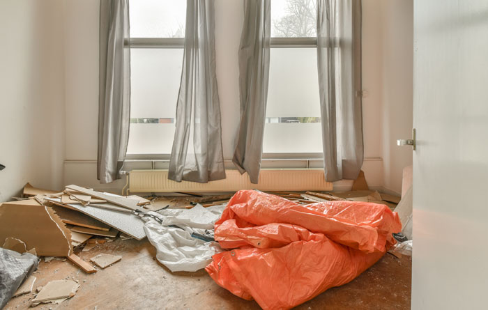 A landlord's nightmare: a room filled with construction debris and orange tarps, illustrating a challenging tenant story.