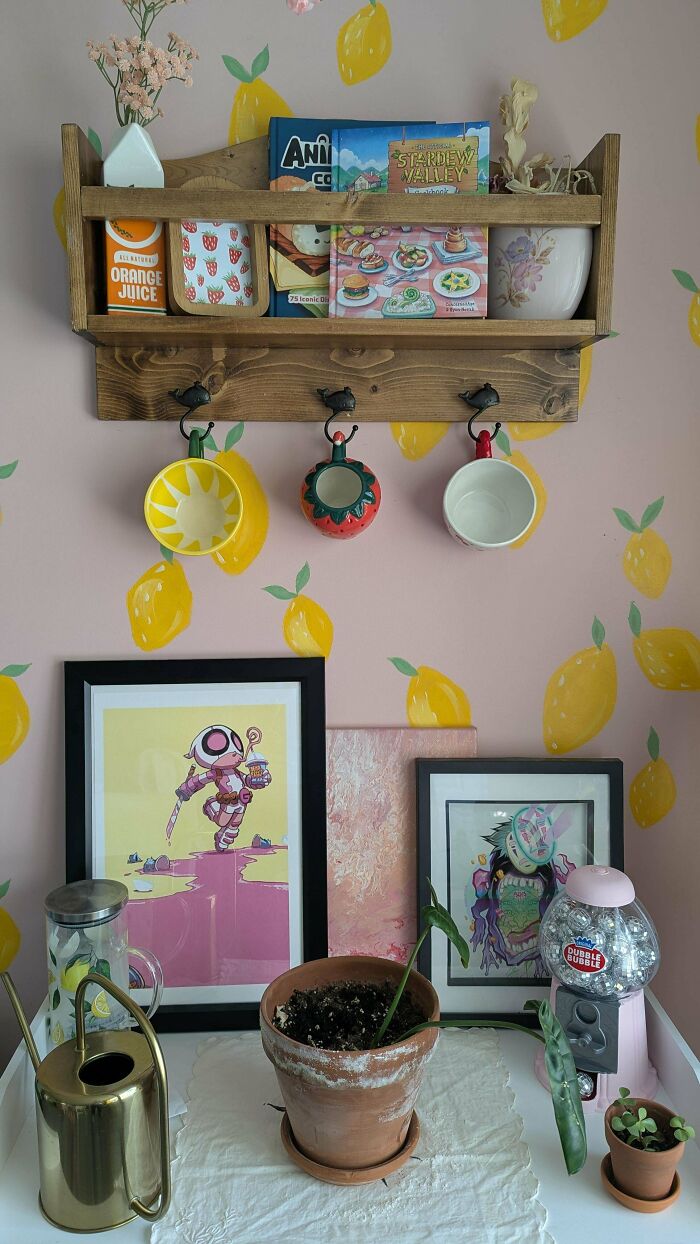 Wooden shelf with hanging mugs and decorated lemon wallpaper in kitchen