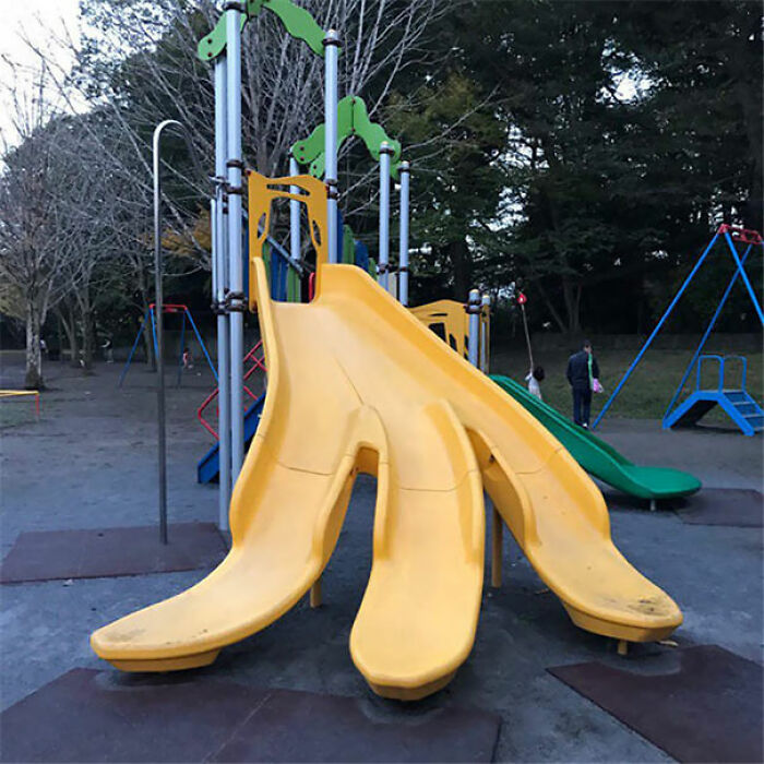 A playground fail of a large, yellow slide with multiple exits, creating an unusual and potentially confusing design.