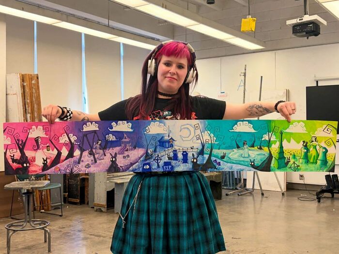 Artist with pink hair holding colorful fantasy illustration quirky art project