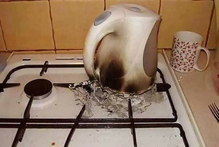 A melted kettle and melted plastic on a gas stove, illustrating a significant kitchen fail.