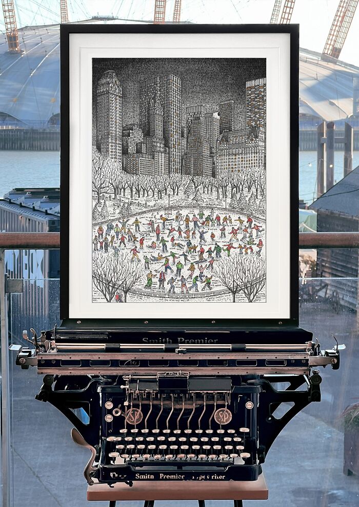 A framed piece of Typewriter Art showcasing a winter scene with ice skaters in a park, set behind a vintage typewriter.