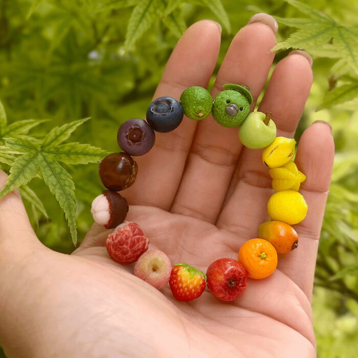 Hand holding colorful mini fruit charm bracelet in nature setting quirky projects