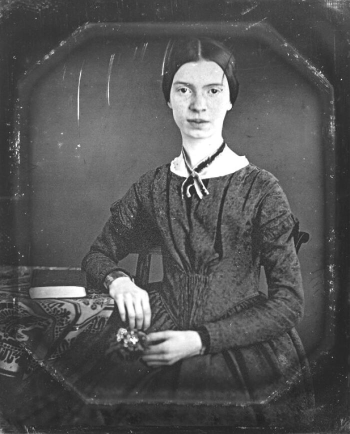 An old, black and white portrait of a young Emily Dickinson, a woman in history.