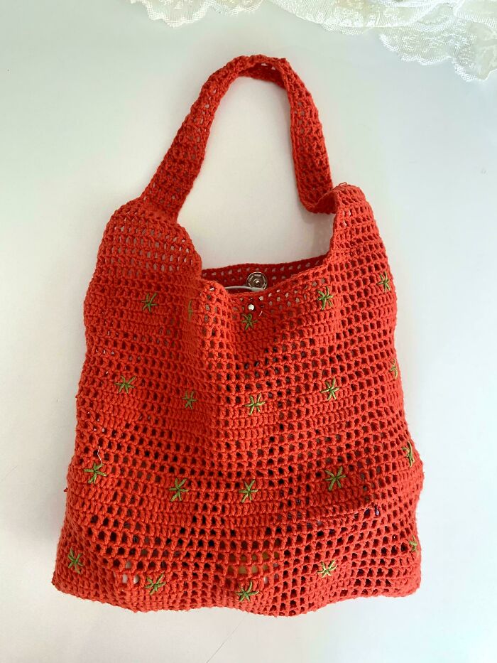 Red crochet handbag with green embroidered details and handle