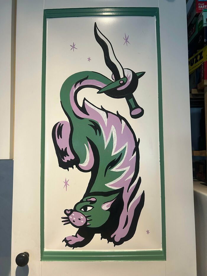 Abstract quirky animal painted on a white door with green frame