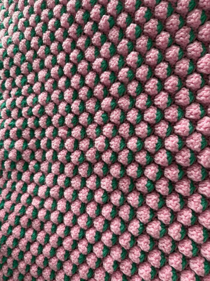 Close-up of pink and green crochet bubble stitch blanket pattern