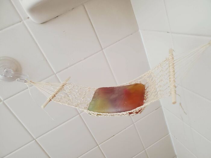 Crocheted mini hammock holding a bar of soap in a tiled shower