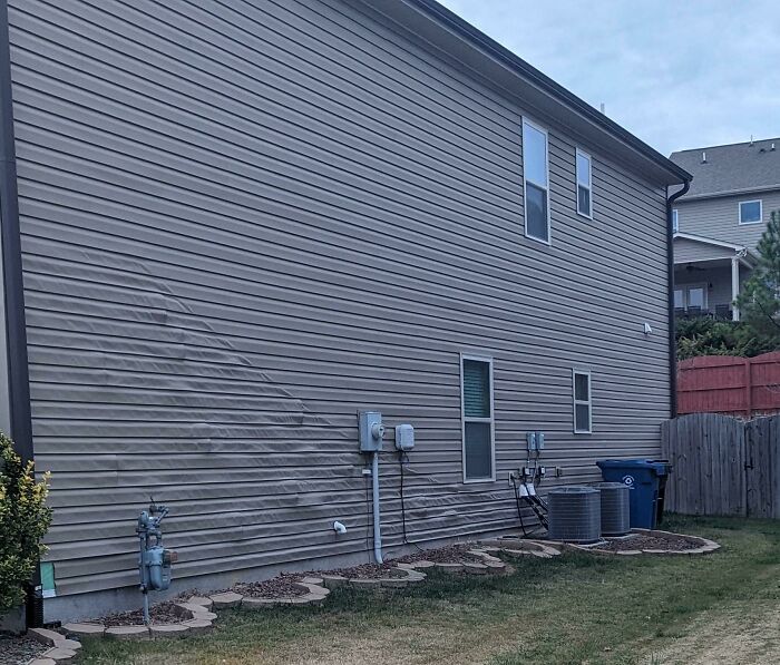 A bizarre thing: the vinyl siding of a house with a wavy, unusual pattern, making it look like it's hallucinating.