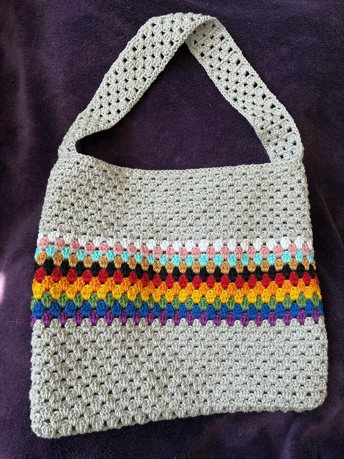 Crochet handbag with vibrant rainbow patterns and textured stitches