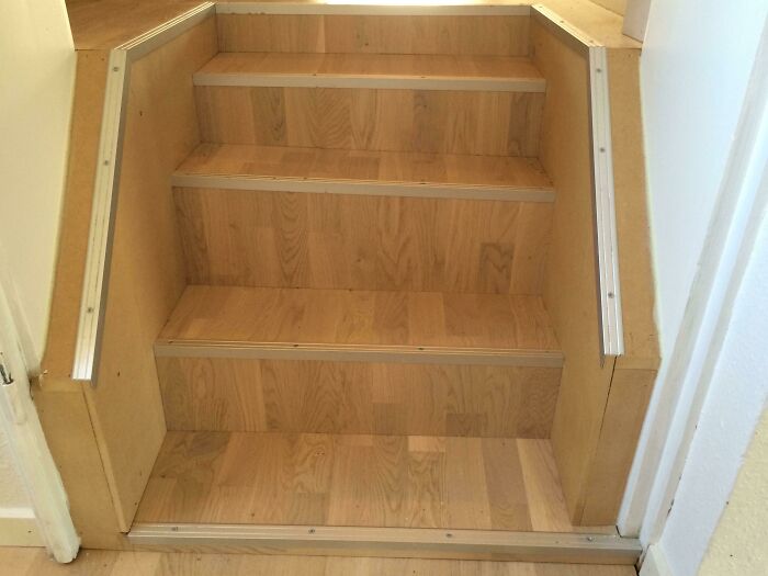 A set of wooden stairs with metal trim, a DIY fail in home renovation.