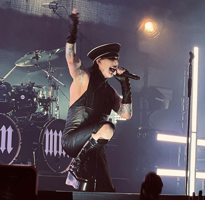 Energetic concert singer performing live with microphone and stage lights