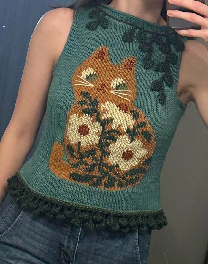 Crochet sweater with a cat and floral design worn by a person