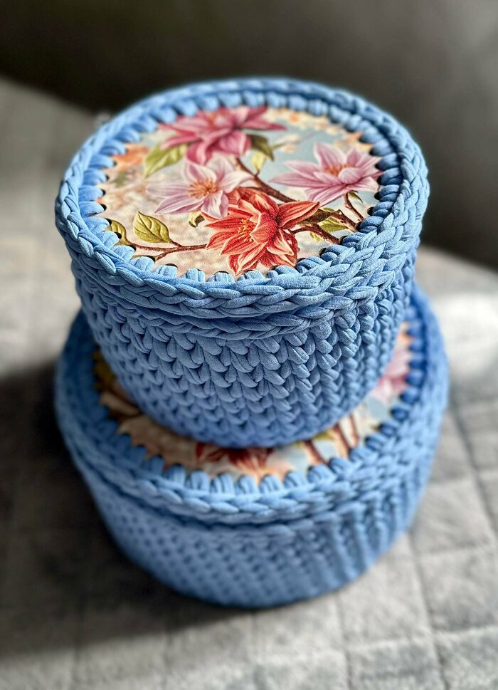 Blue crocheted storage baskets with floral fabric lids