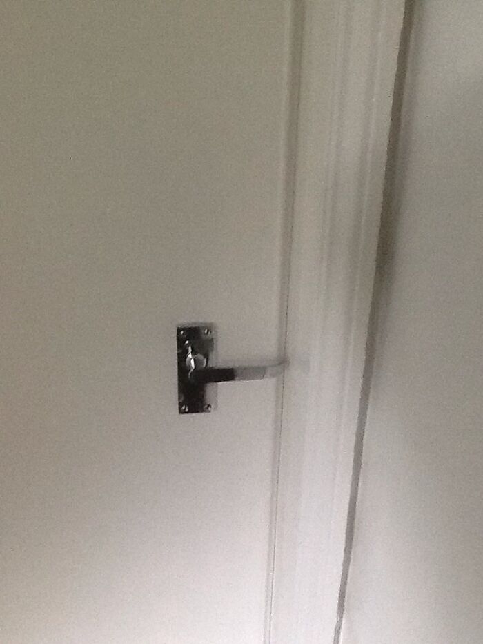 A white door with a poorly installed door handle, clearly a DIY fail.