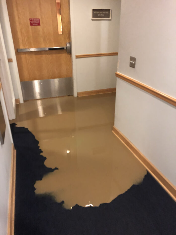 A hallway with dirty water flooding the floor, highlighting an example of forbidden foods to avoid.