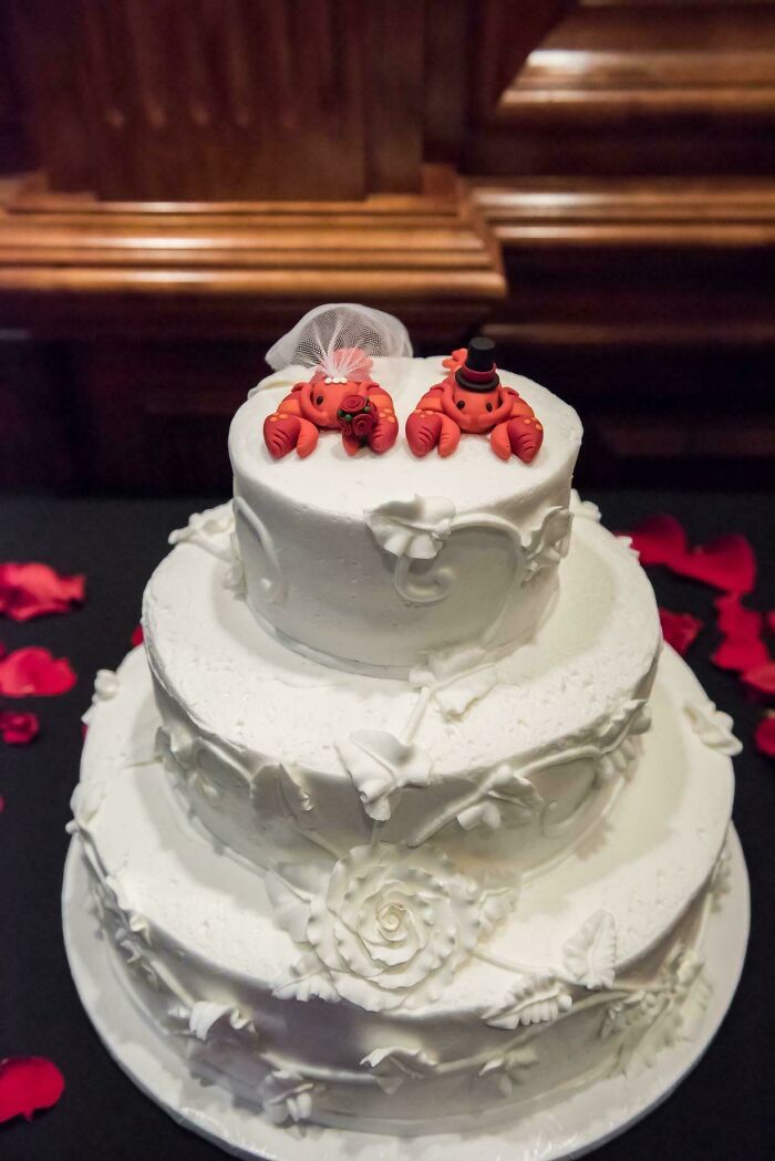 White wedding cake decorated with crab figurines as quirky project cake topper