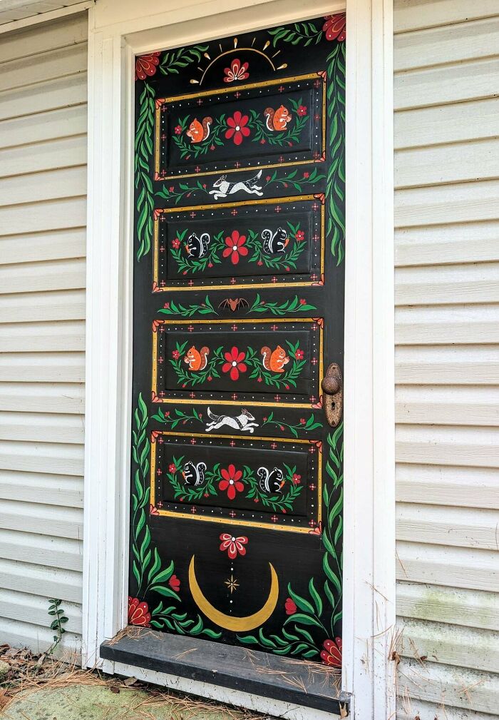 Black door painted with colorful squirrels and plants quirky door art