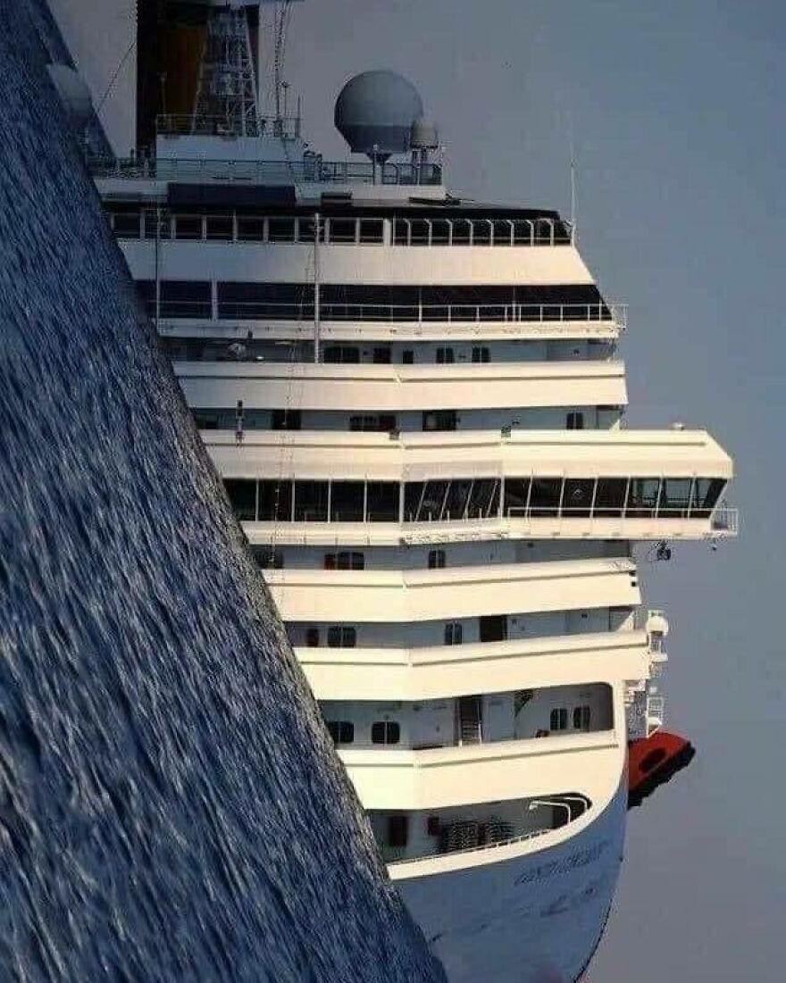 Disturbing pic of a cruise ship tilted at an extreme angle, creating an uncomfortable and chaotic scene.