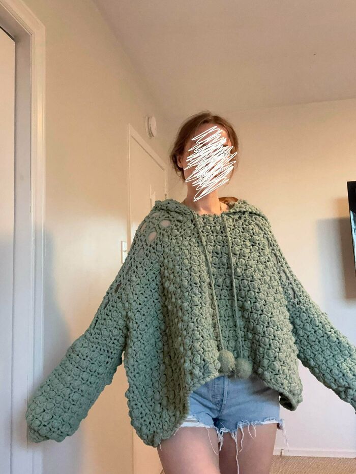 Green chunky crocheted sweater with hood and pom-poms