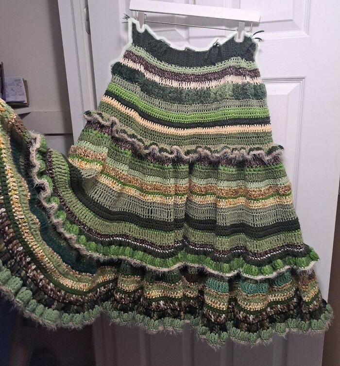 Green striped crochet skirt with ruffle details hanging on a door