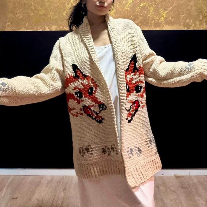 Person wearing cream cardigan with crocheted fox design