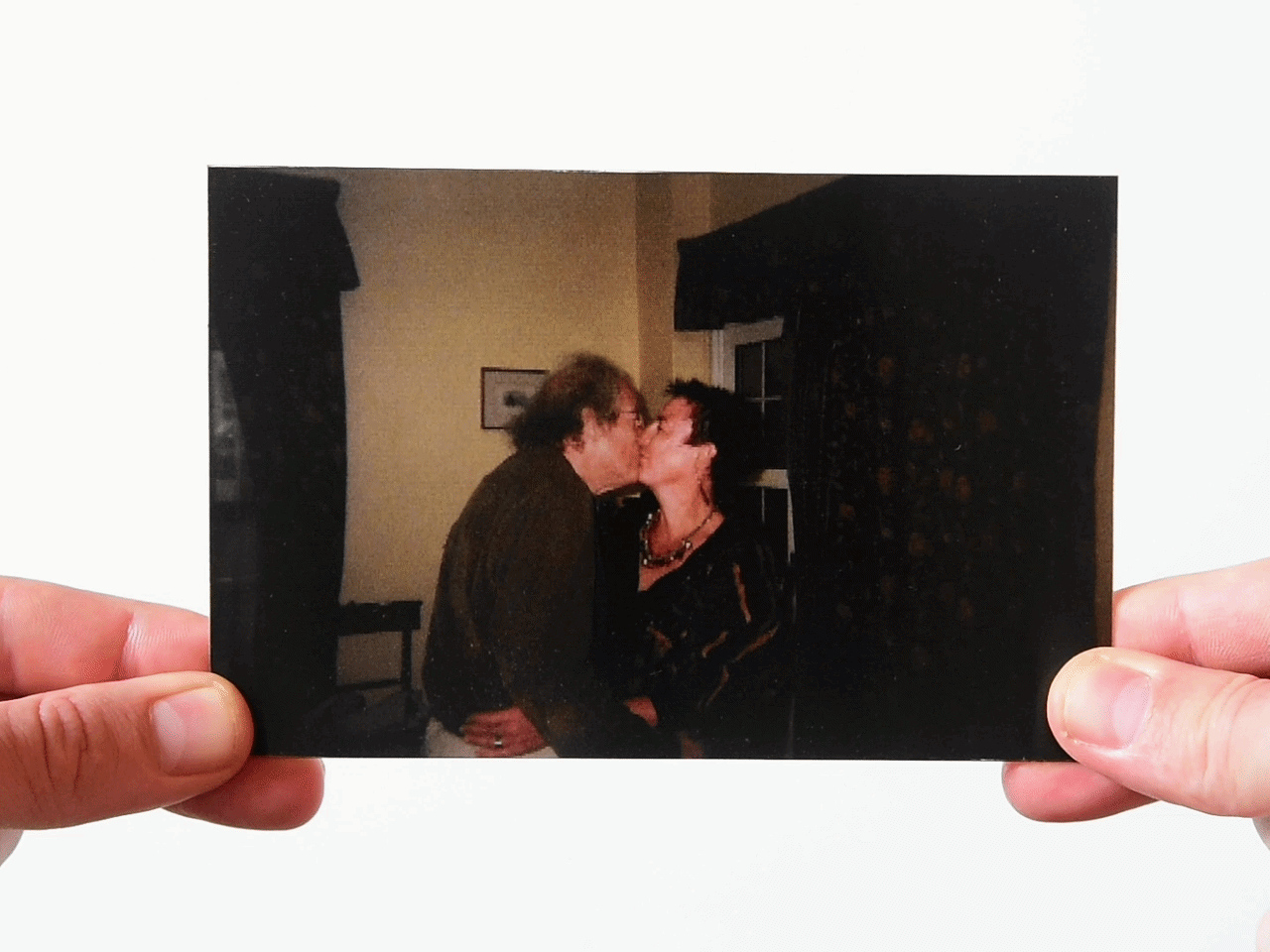 Parents kissing indoors in a vintage childhood photo