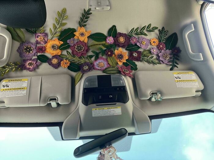 Purple and orange felt flower decoration on car sun visor quirky decor