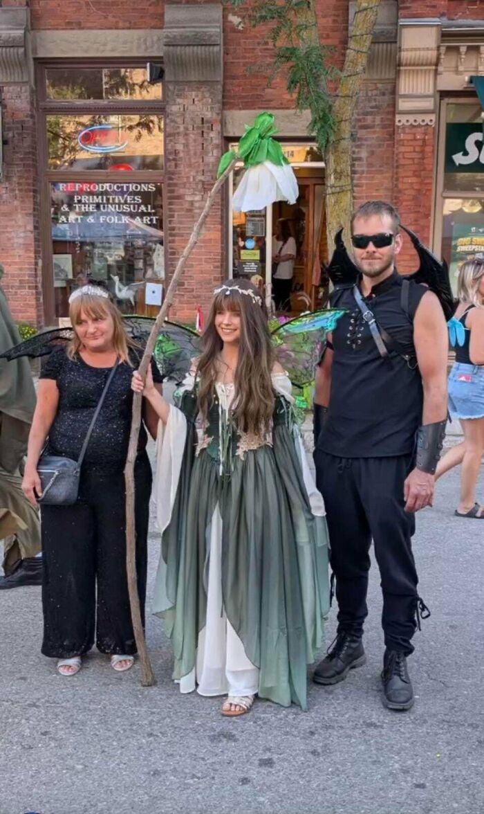 Group in fantasy costumes including fairy and gothic wings outdoors