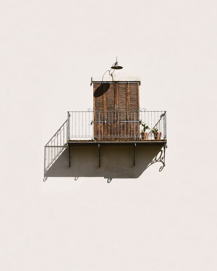 Photographer's minimalist art: a simple balcony with closed wooden shutters against a plain wall.
