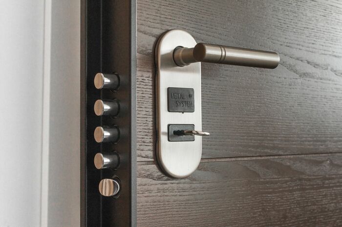 Close-up of a modern secure door with multiple locks, showing safety tips for women living alone.