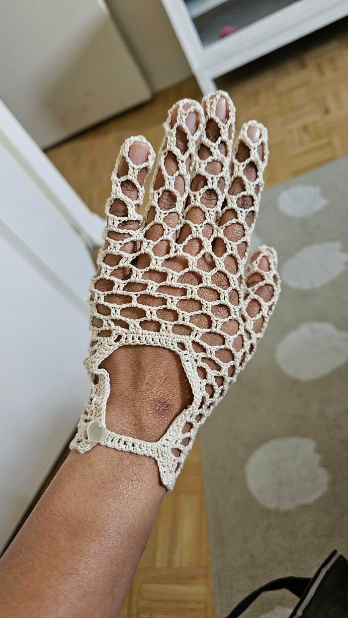 Close up of openwork crochet glove made with beige yarn
