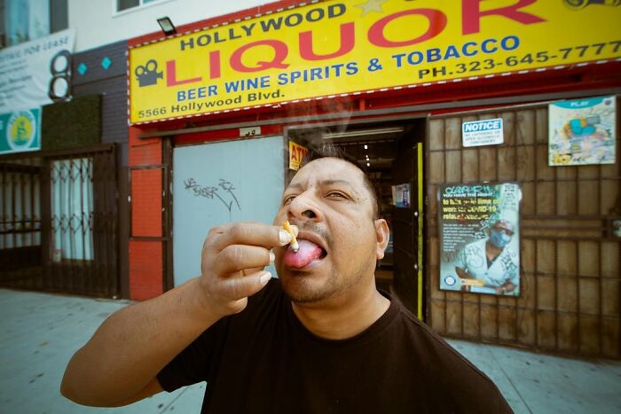 Jeremy Paige captures a perfectly timed street photo of a man eating in front of Hollywood Liquor.