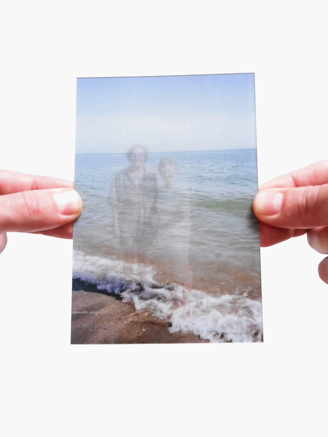 Childhood photo overlay showing father and child ghosted over beach ocean scene