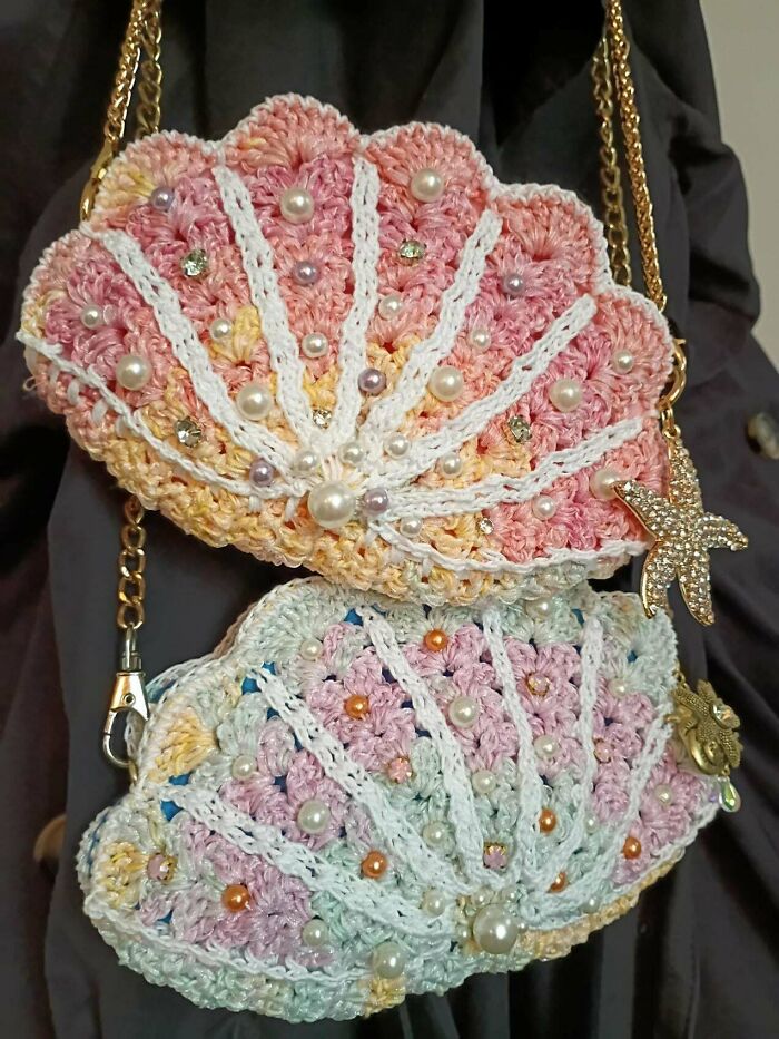 Crocheted seashell shaped bags decorated with pearls and beads hanging on a chain