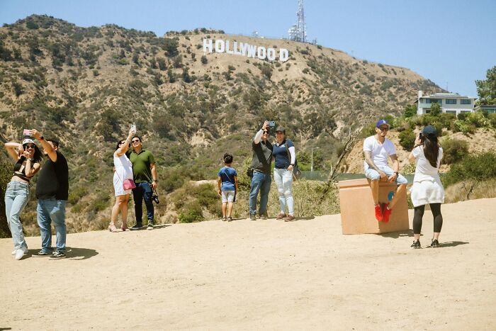 A perfectly timed street photo by Jeremy Paige, with tourists taking photos of the Hollywood sign.