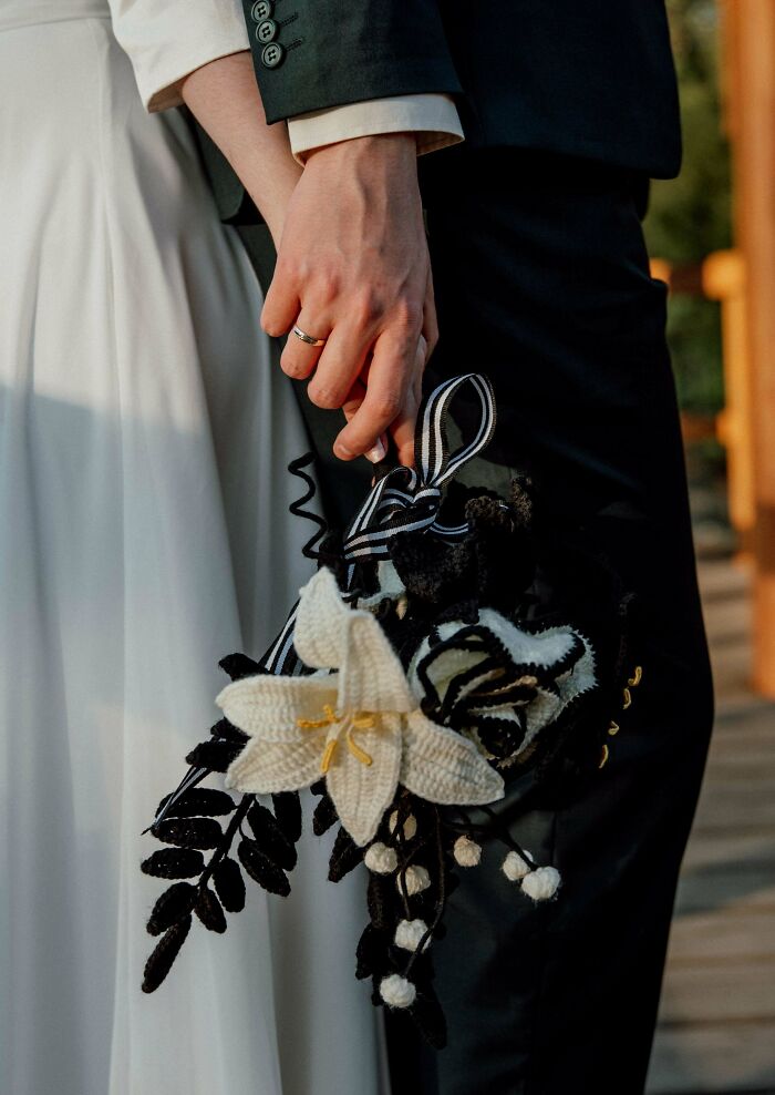 Black and white crocheted floral bouquet with bride and groom holding hands