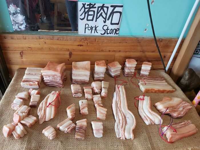 Display of Pork Stone, a collection of intricately carved stones resembling pork belly. This image is one of the forbidden foods.