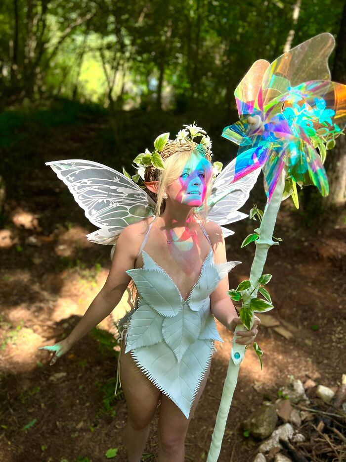 Woman in fairy costume with wings and staff in forest, quirky projects cosplay