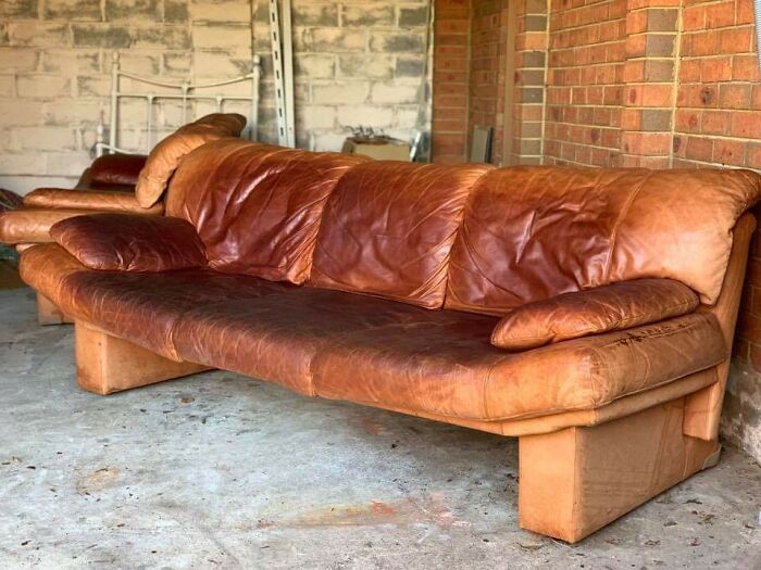 An old, worn brown leather couch in a garage. This image is one of the forbidden foods.